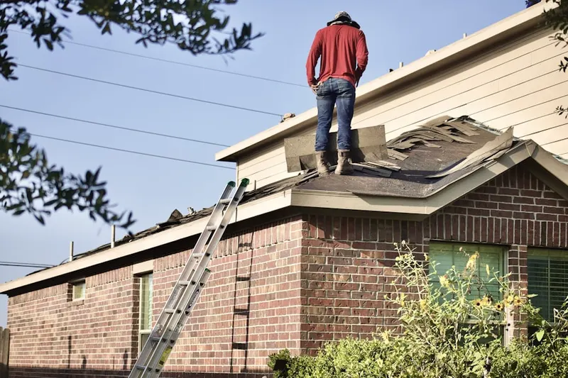 Professional roofer working on a residential roof in Regis